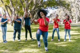 Group of People Cheering For The Woman In Red Shirt